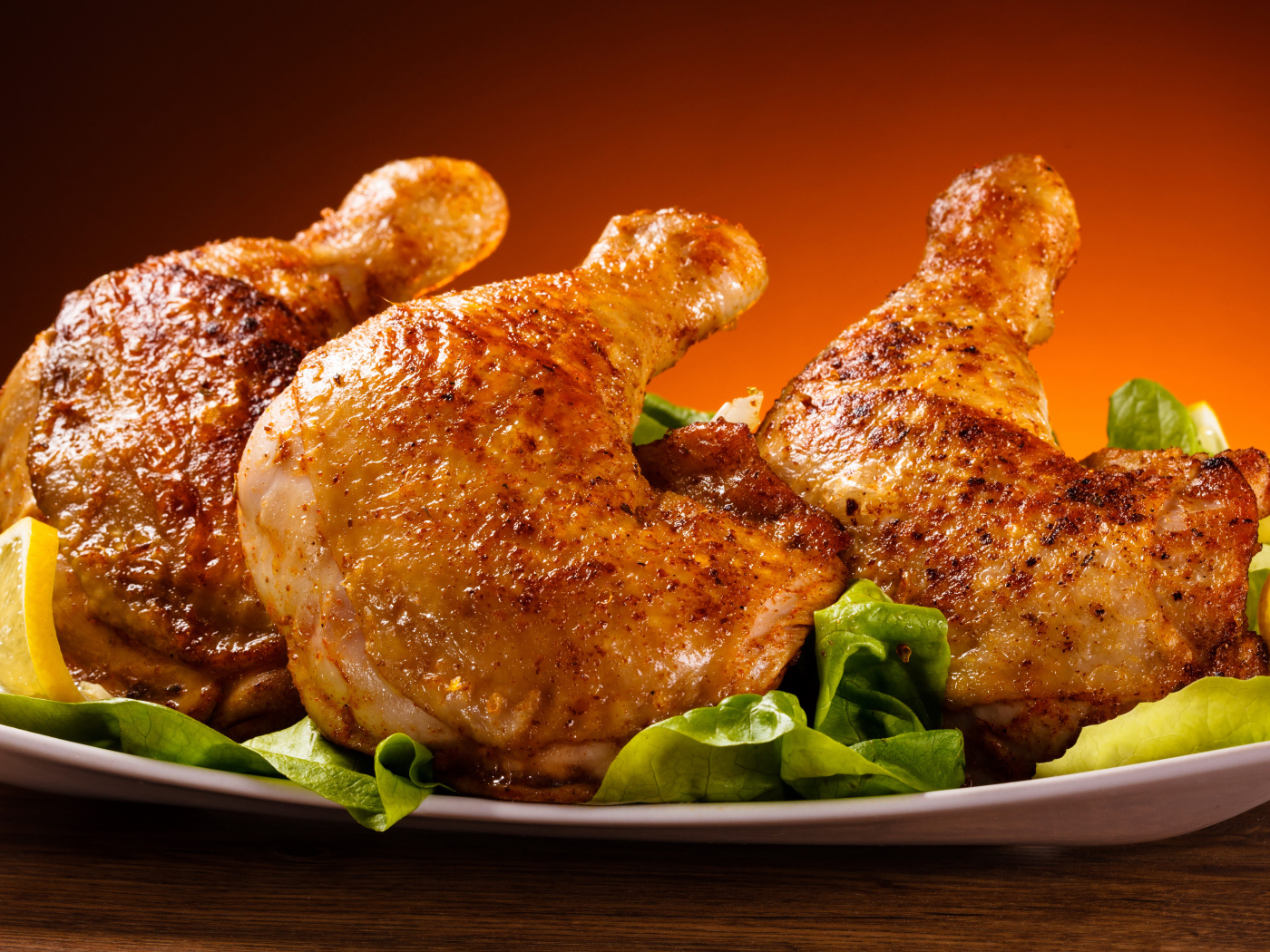 Жареные куриные окорочка на зеленых листьях салата 