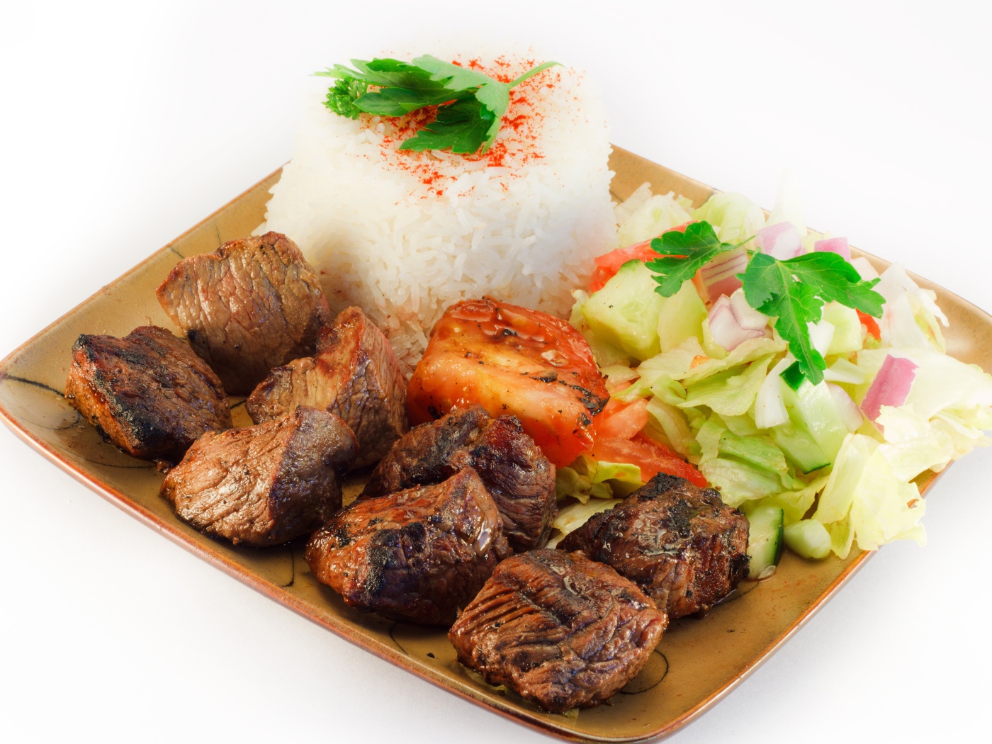 Шашлык с рисом и овощами в тарелке на белом фоне