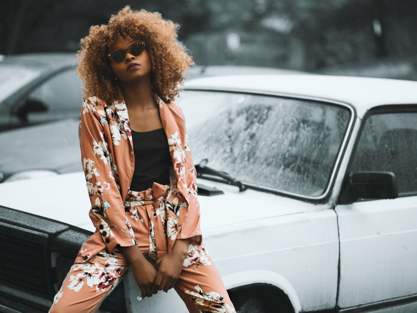 Красивая темнокожая девушка сидит на автомобиле 