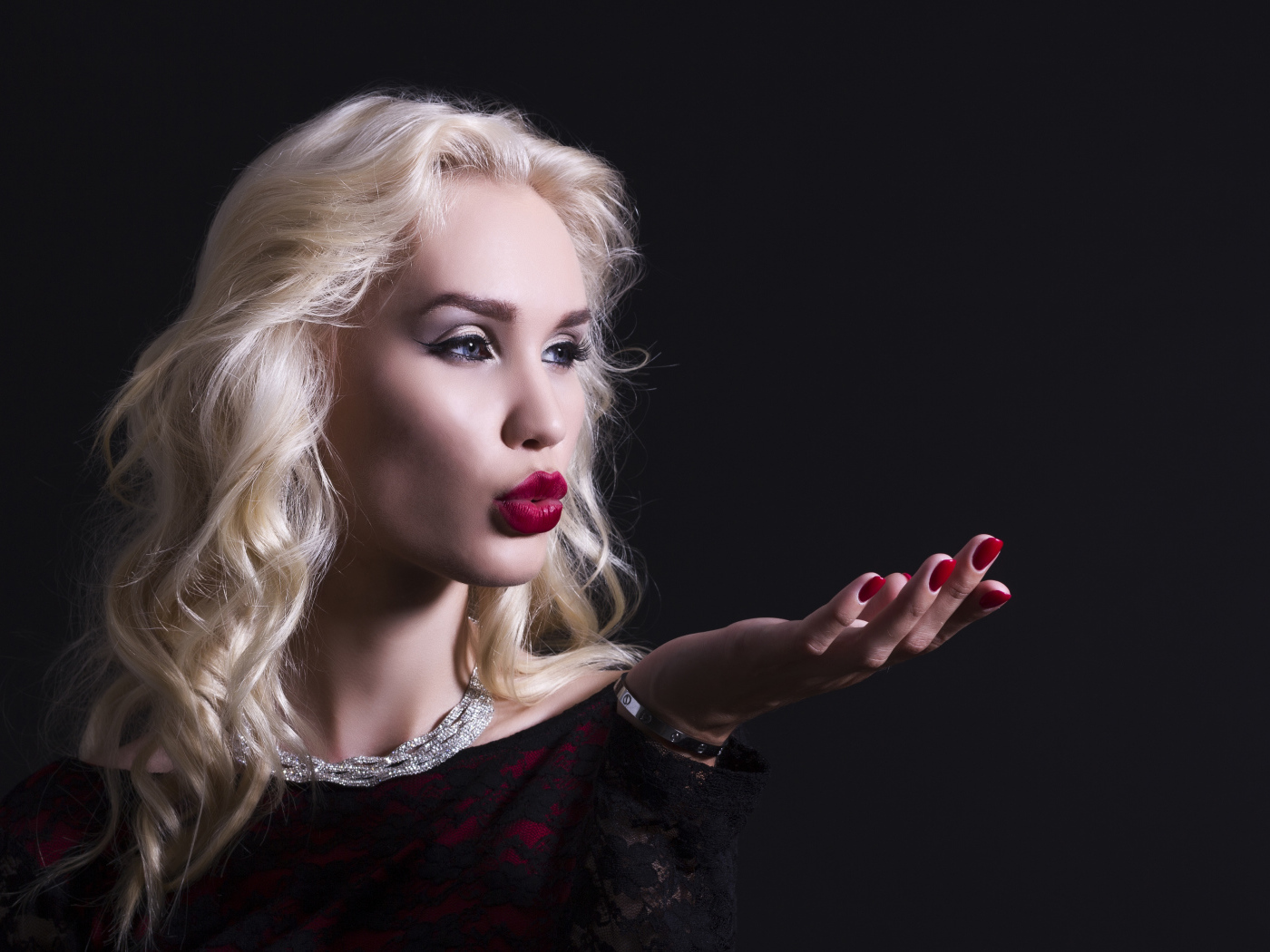 Красивая голубоглазая блондинка с красными губами в черном платье