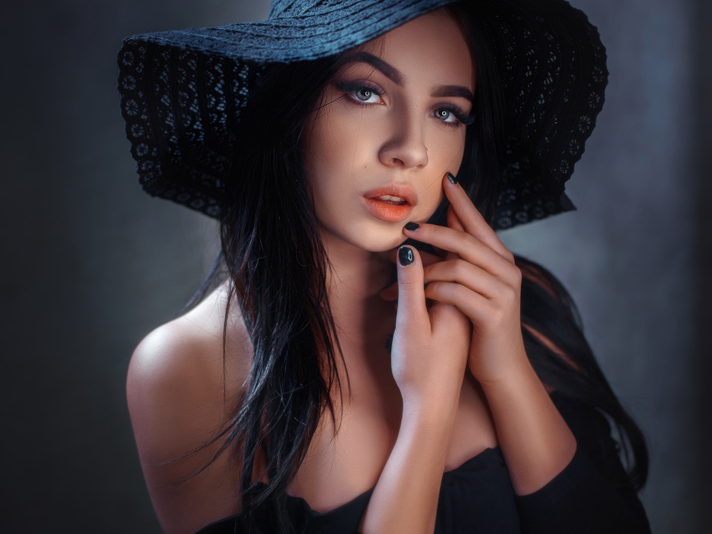 Красивая брюнетка в большой черной шляпе 