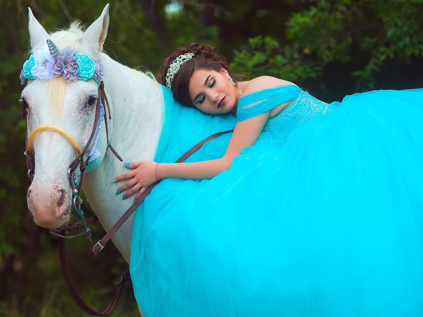 Красивая девушка в пышном голубом платье на лошади