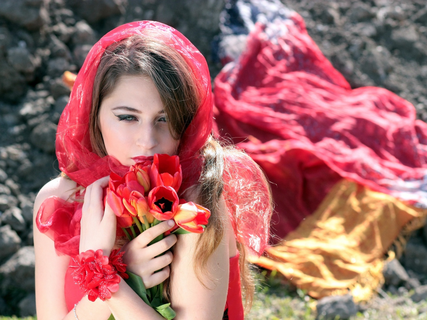 Красивая девушка в красной шали с букетом тюльпанов