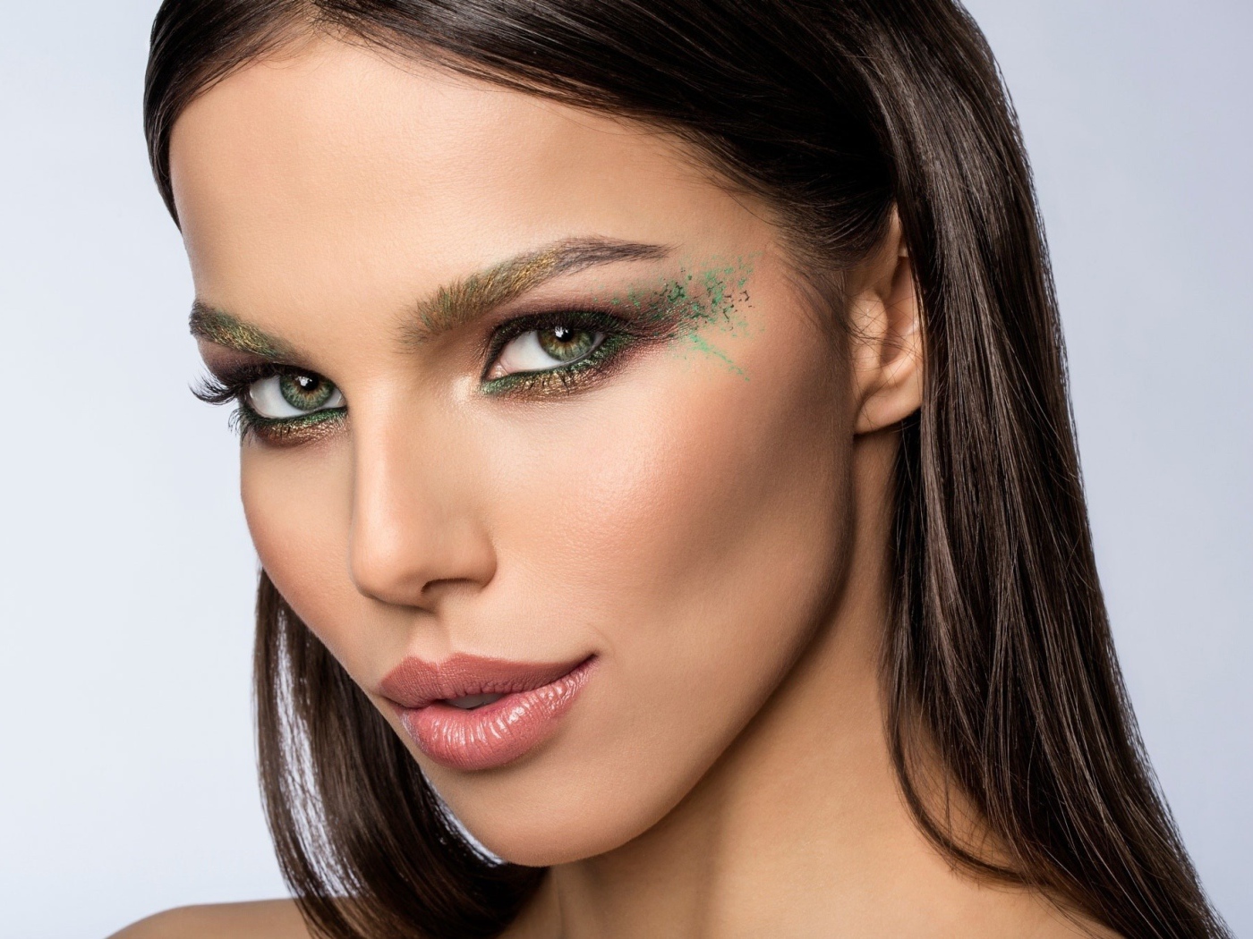 Красивая зеленоглазая девушка с макияжем на лице