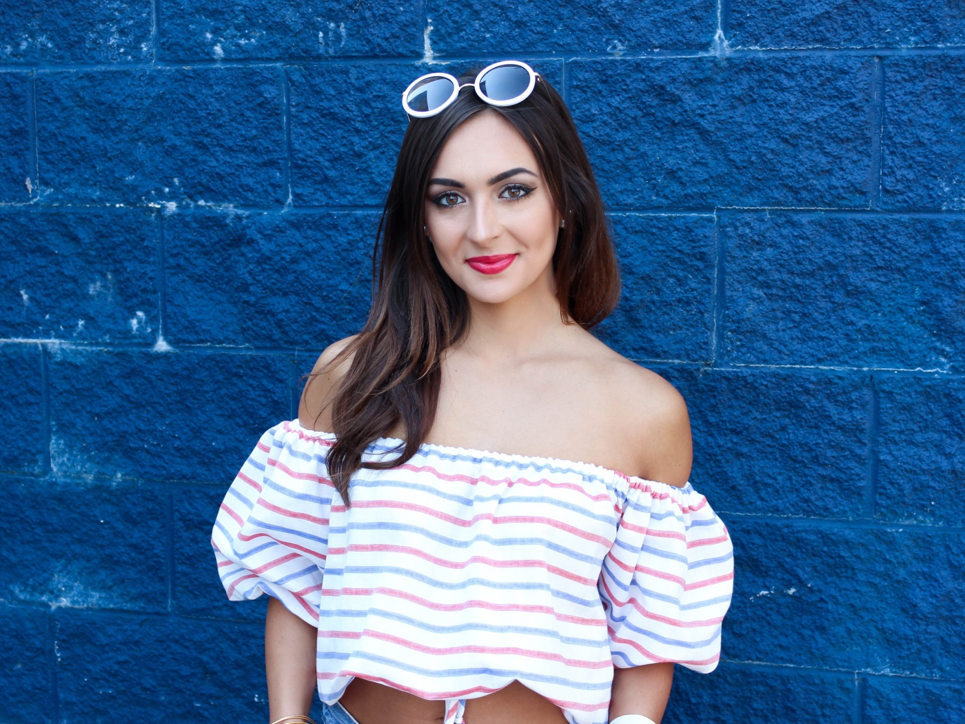 Красивая улыбающаяся девушка на фоне синей стены