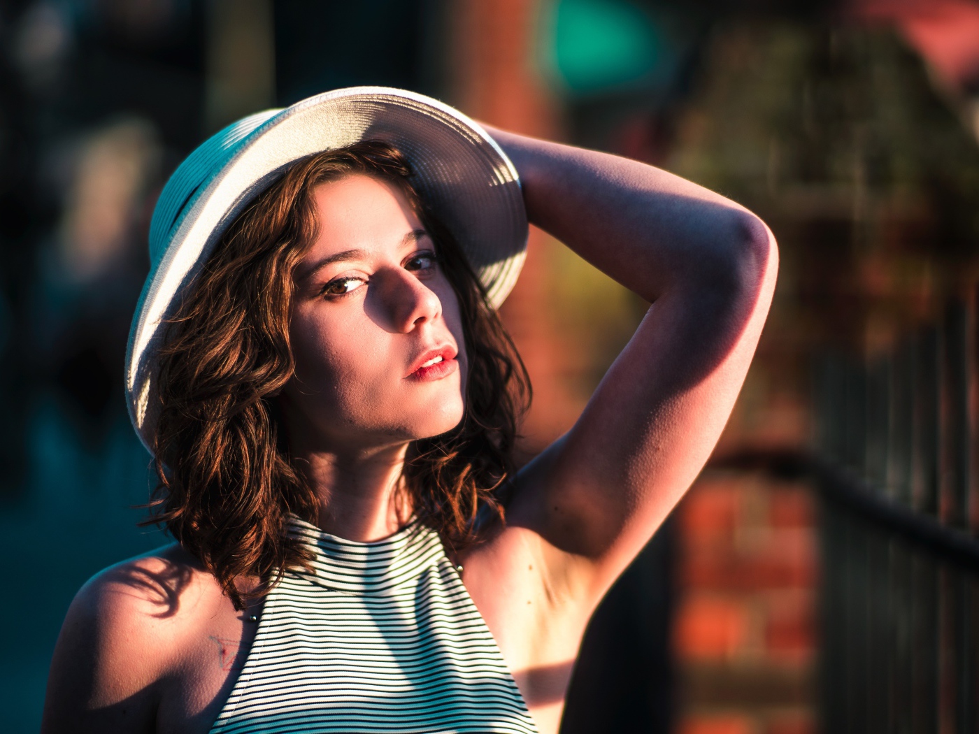 Красивая молодая девушка в белой шляпе в свете солнца