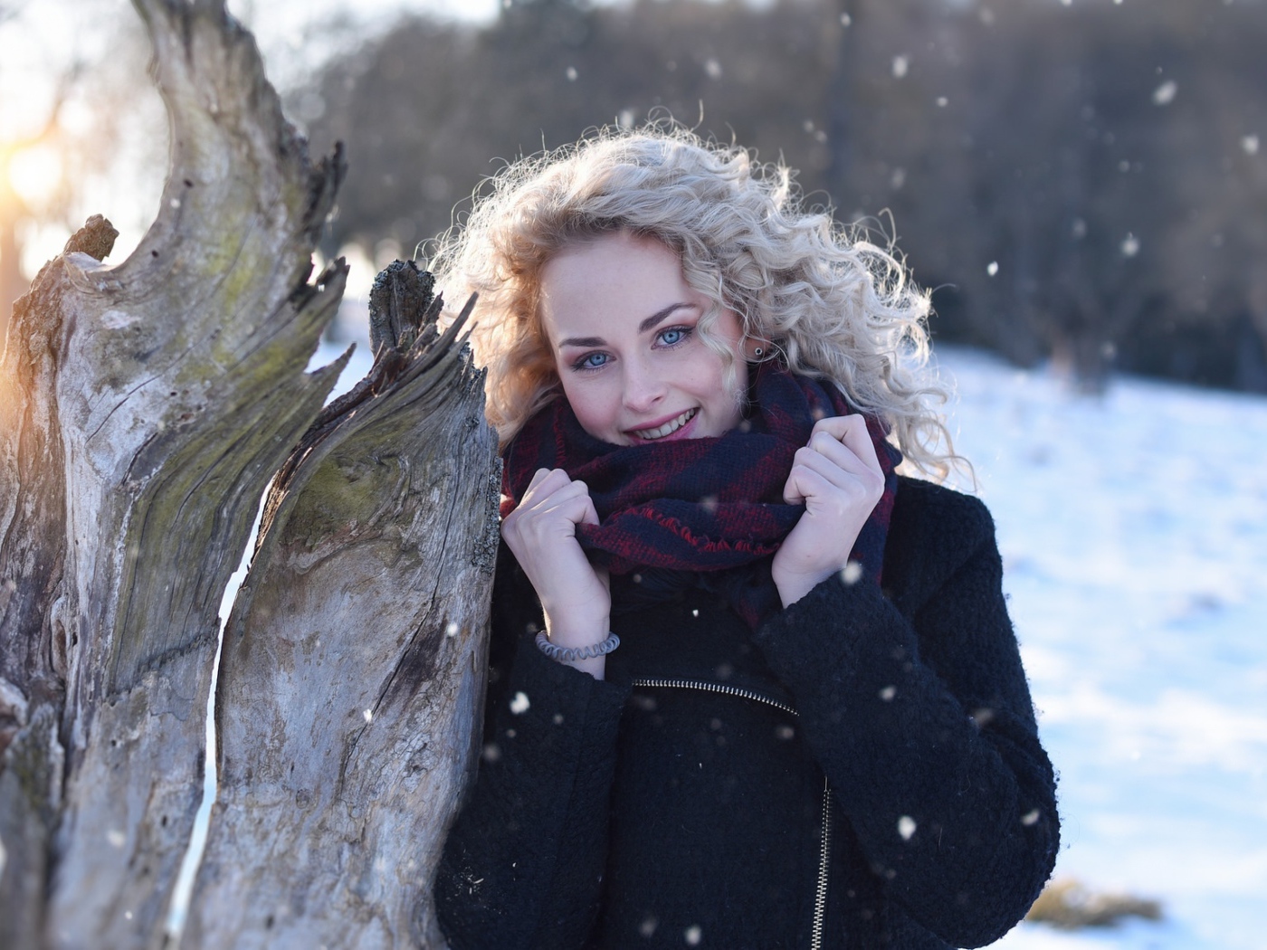 Голубоглазая блондинка у сухого дерева зимой
