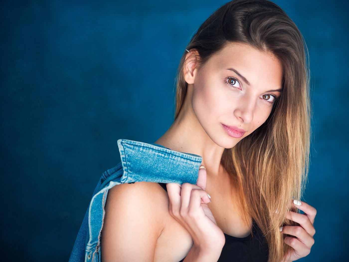 Кареглазая шатенка с джинсовой курткой в руке