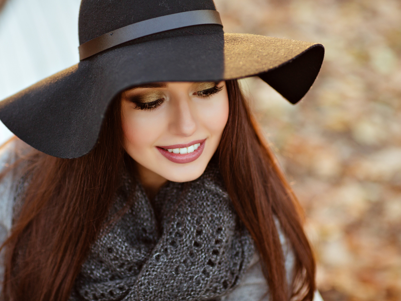 Улыбающаяся шатенка в большой черной шляпе