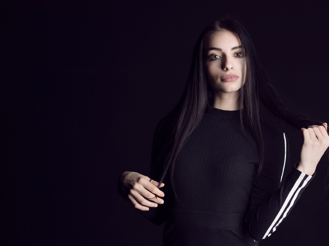 Эффектная брюнетка в черном наряде на черном фоне