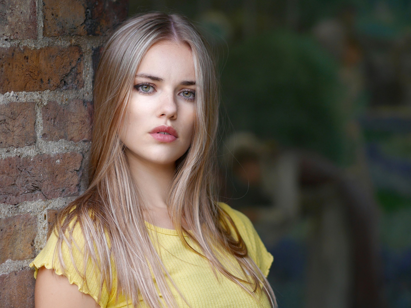 Грустный взгляд красивой светловолосой девушки у стены