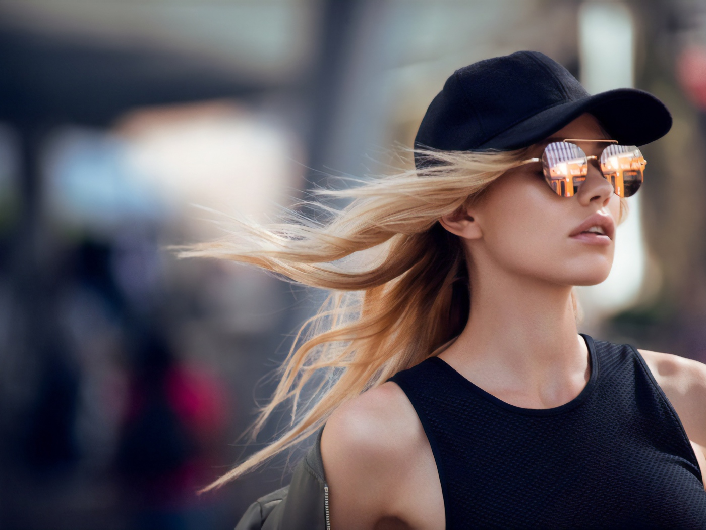 Молодая блондинка в солнечных очках и черной кепке 