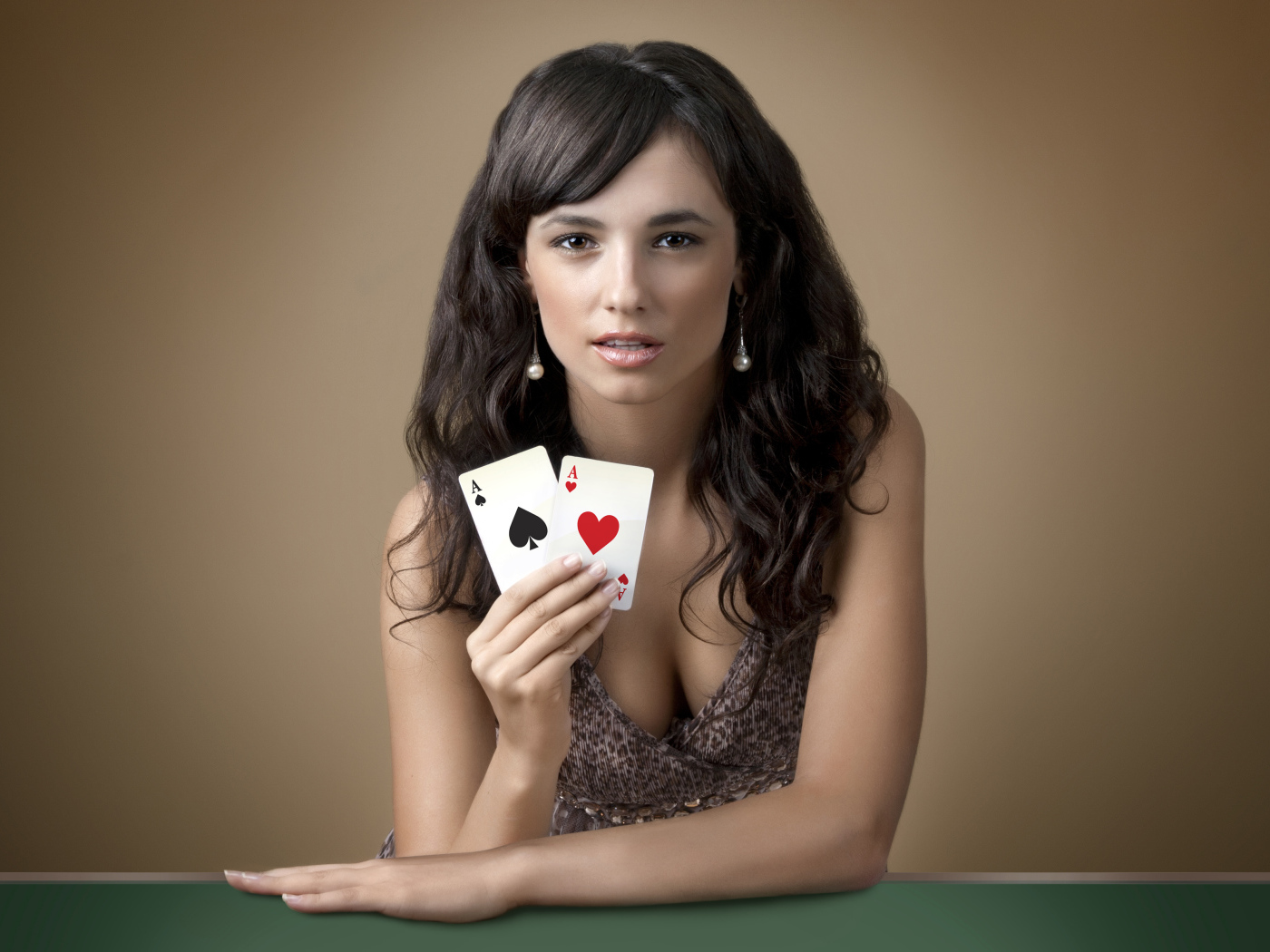 Молодая брюнетка с двумя карточными тузами в руке
