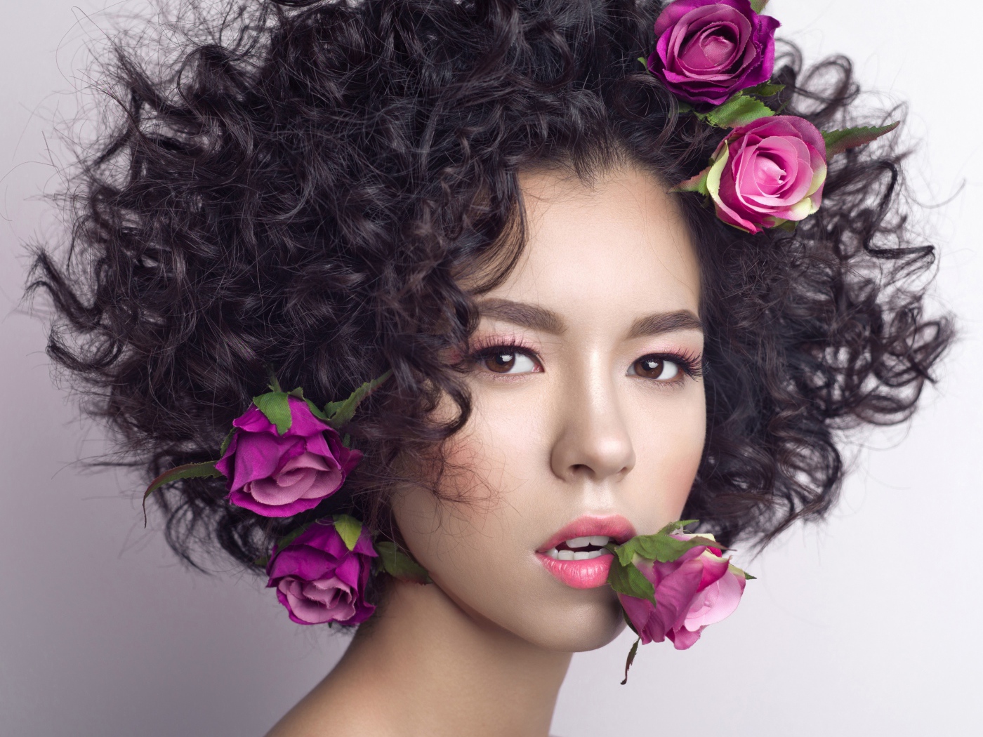 Молодая девушка с кудрявыми волосами с розами