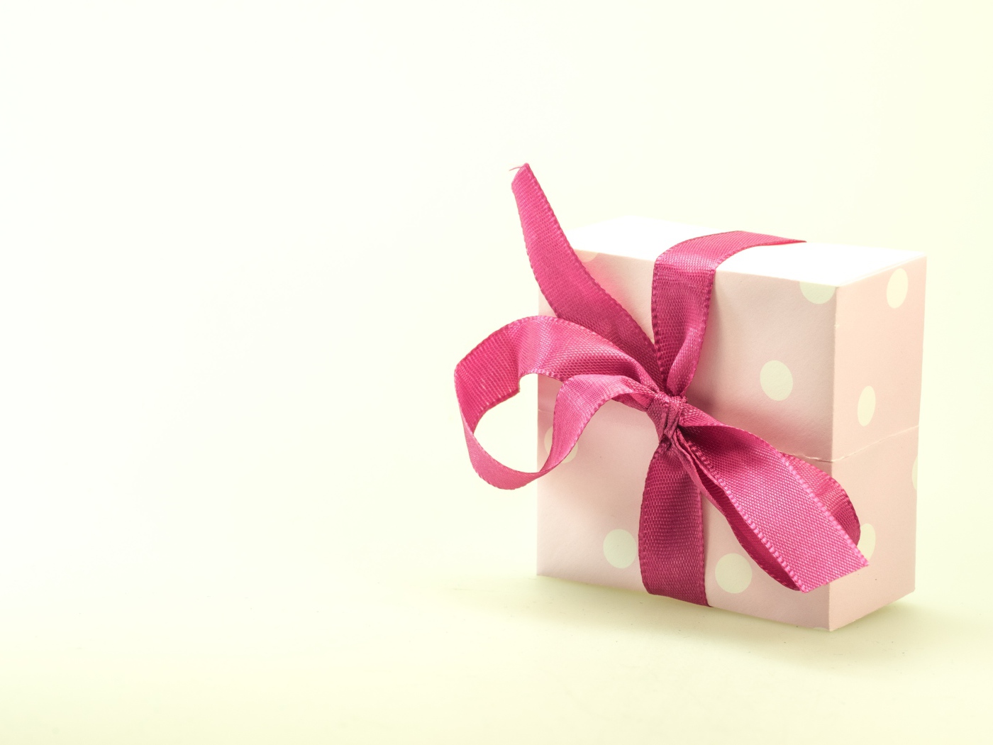 Подарочная коробка с розовым бантом на белом фоне