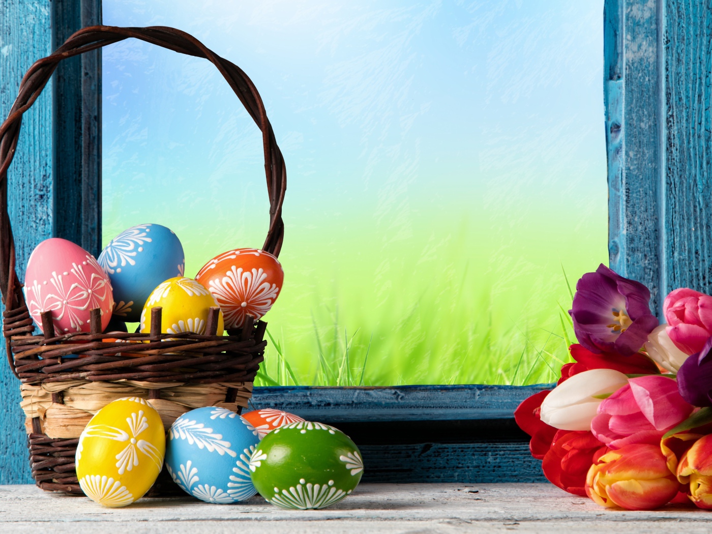 Пасхальные яйца в корзине на подоконнике с букетом тюльпанов