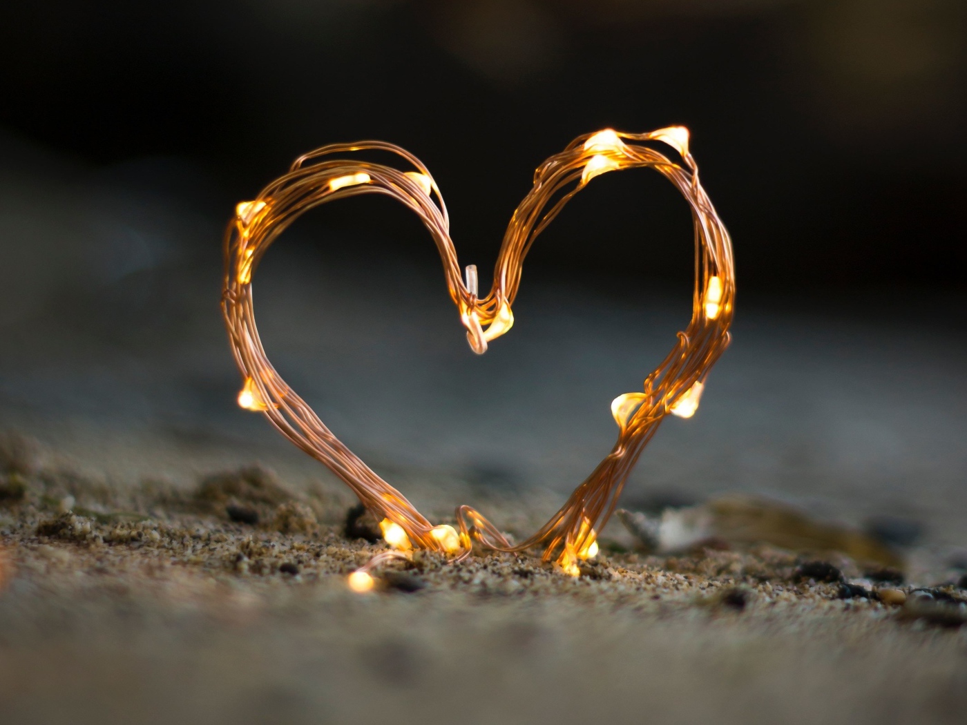Сердце из гирлянды на песке