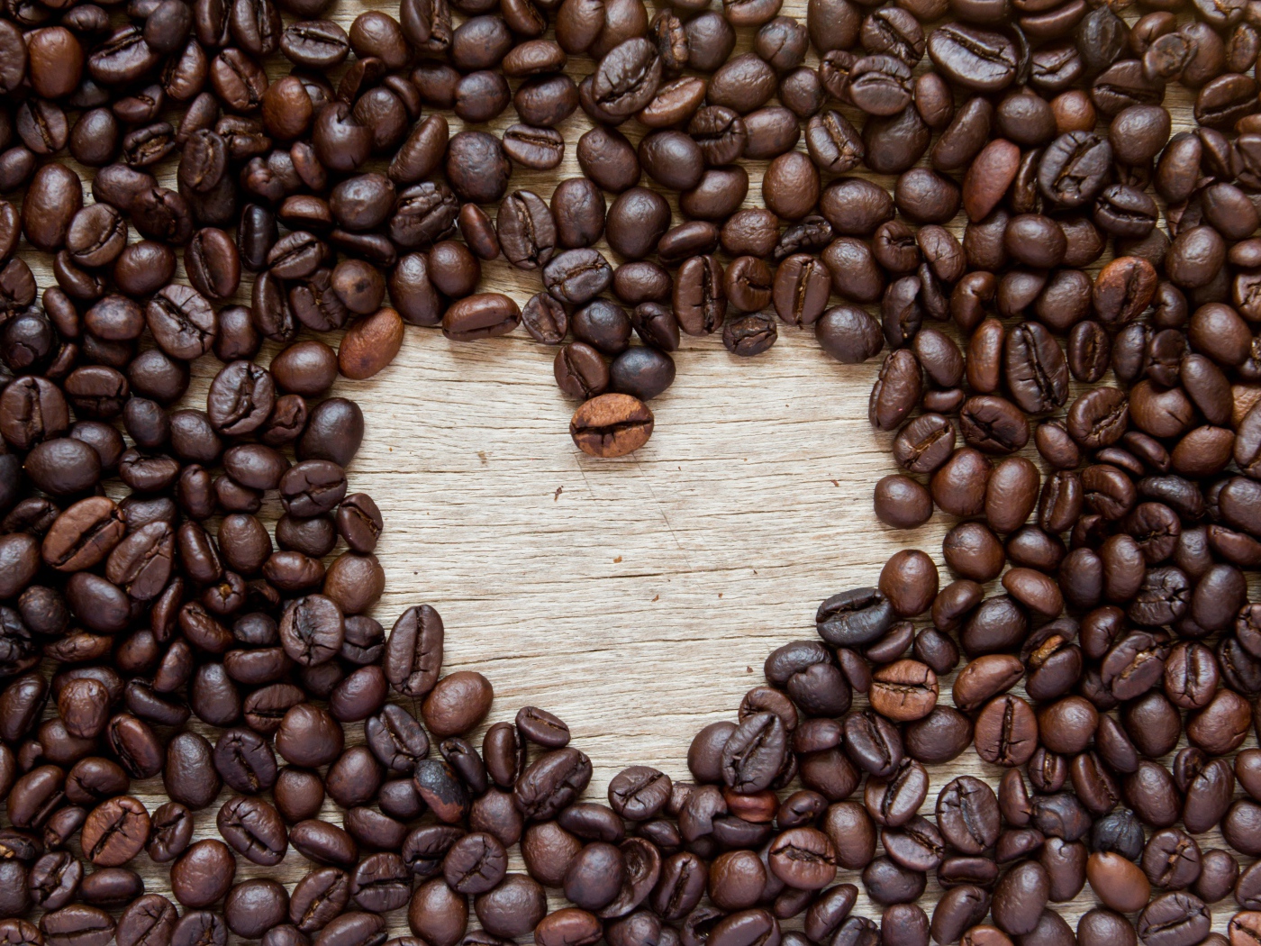 Сердце из кофейных зерен на деревянном столе 