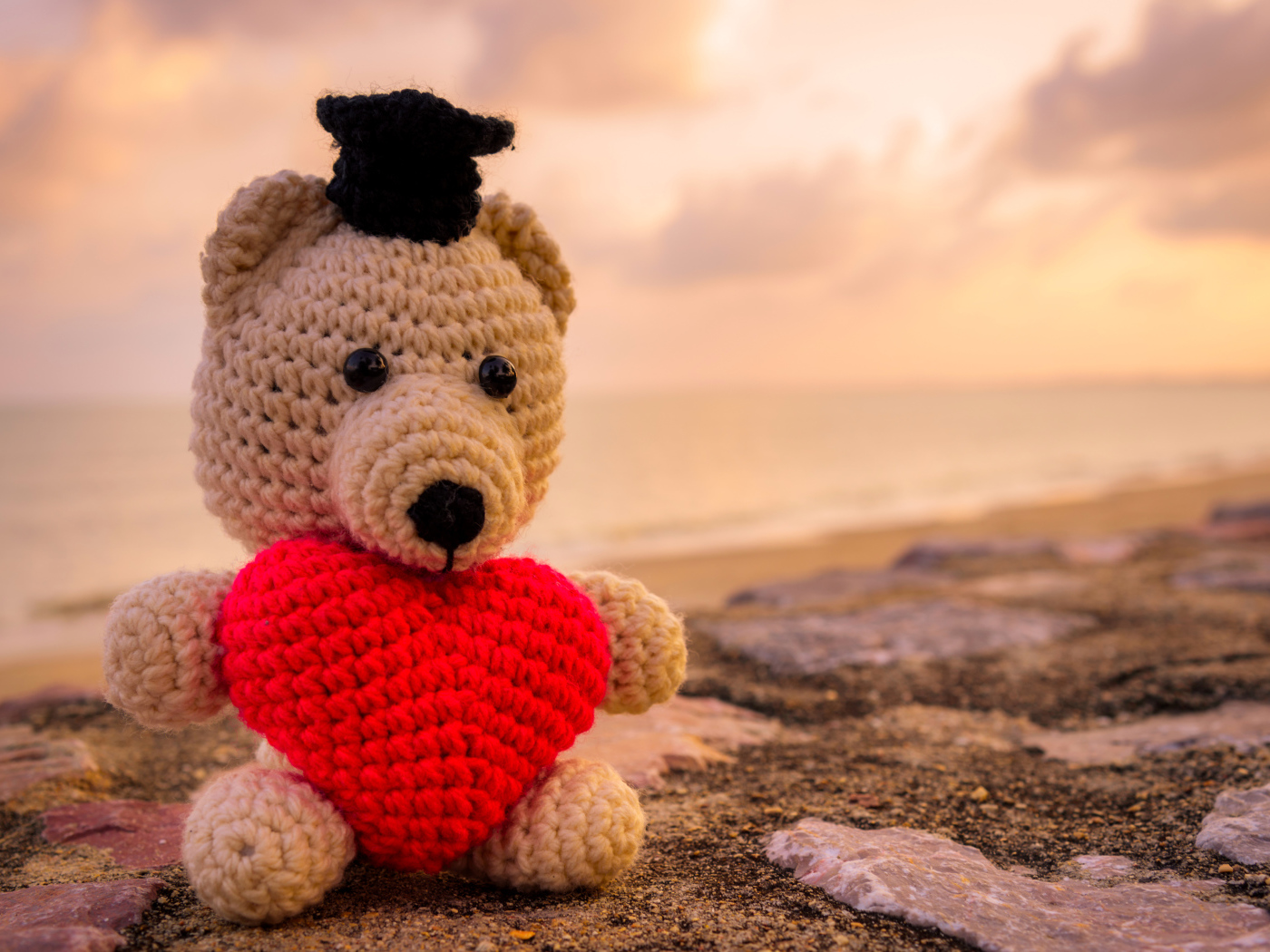 Игрушечный медведь с красным сердцем на фоне неба