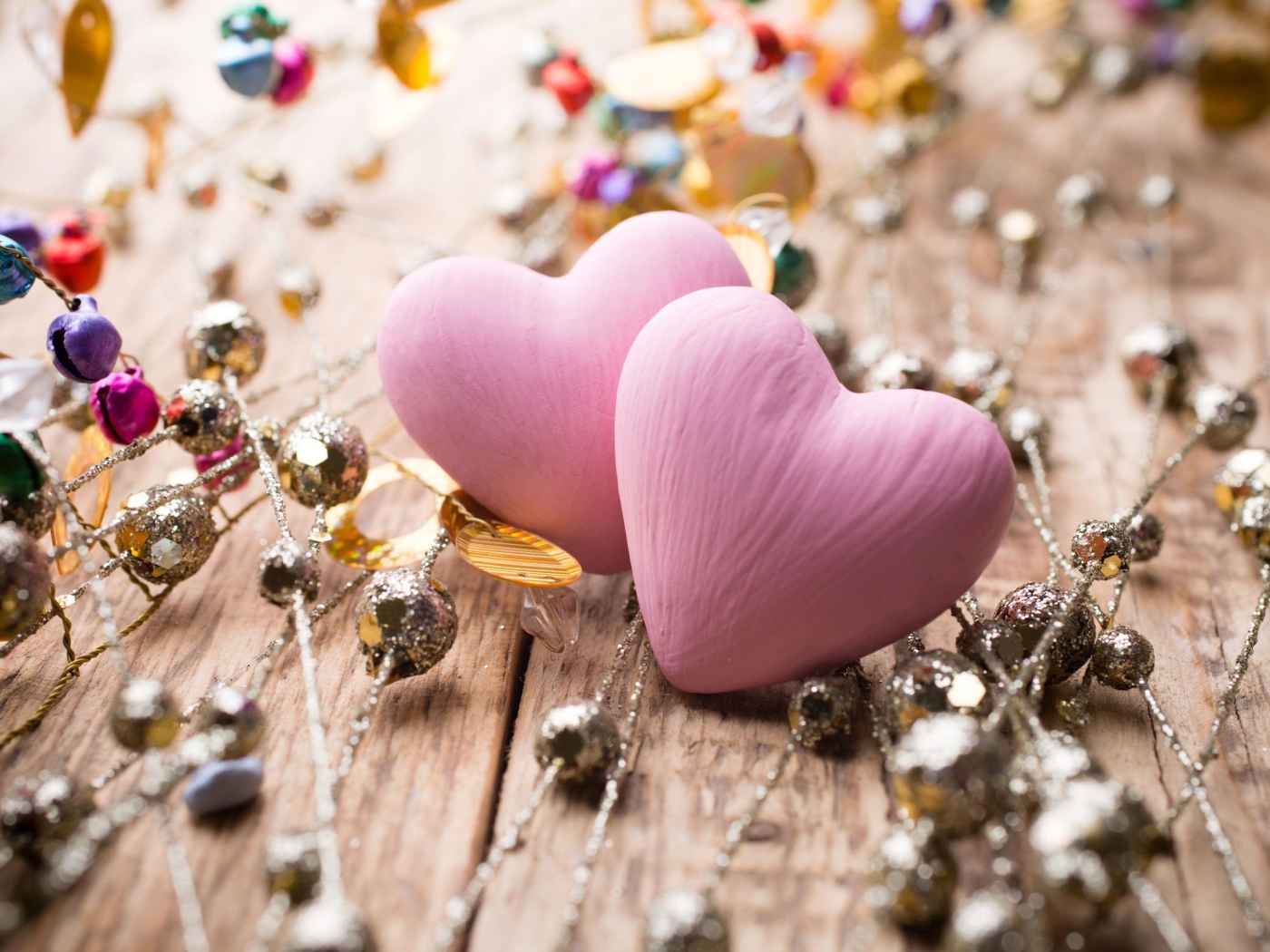 Два розовых сердца на деревянном фоне с элементами декора