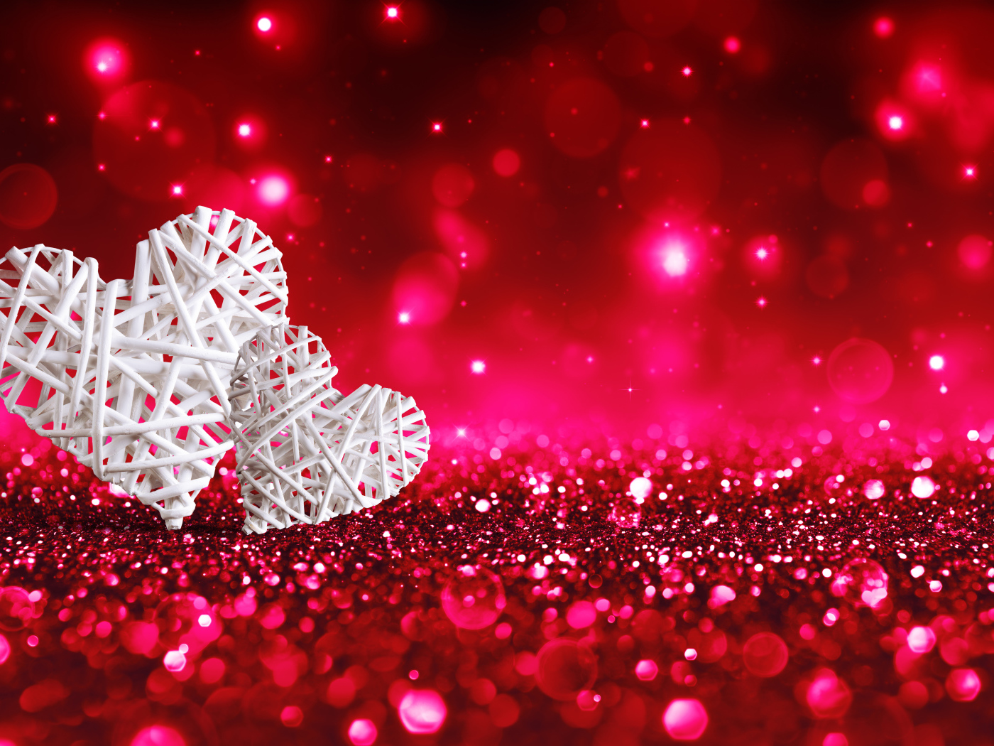 Два белых плетеных сердца на мерцающем красном фоне