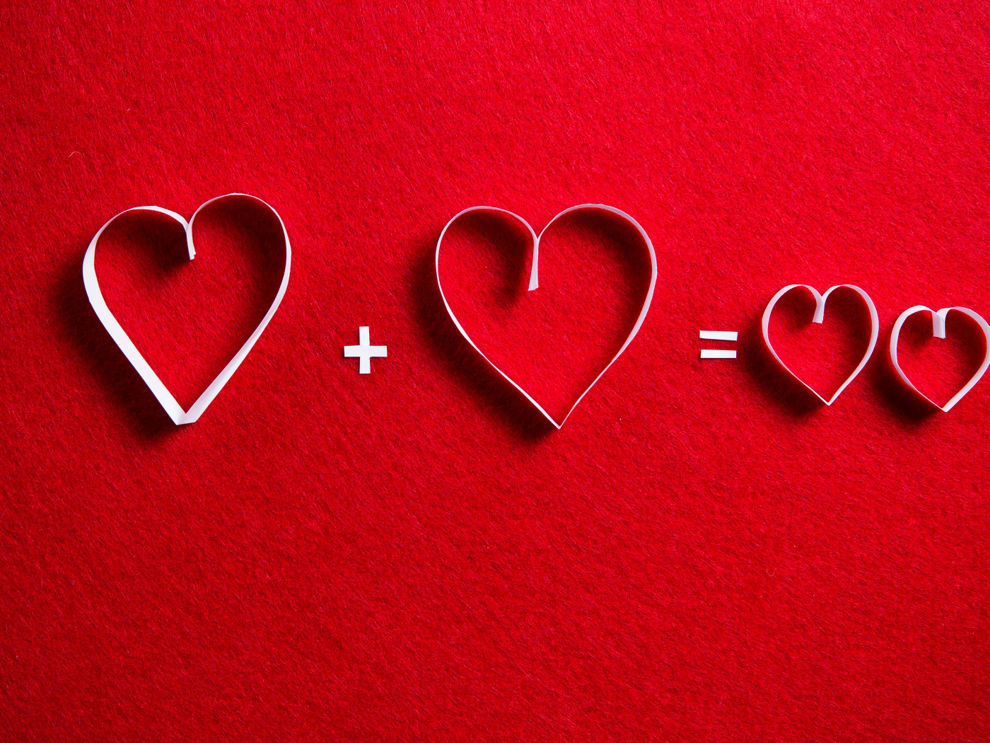 Белые бумажные сердечки на красном фоне