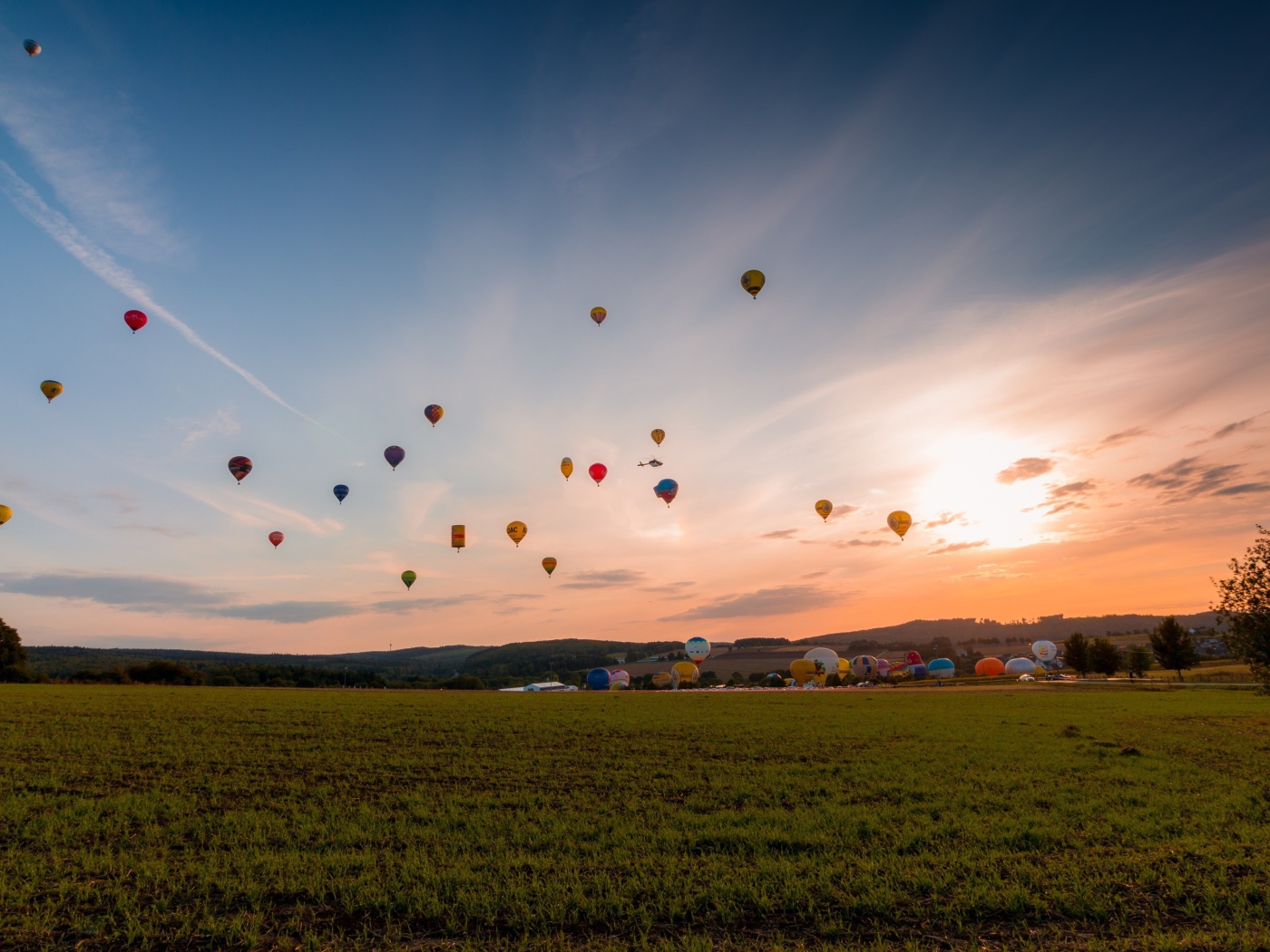 Воздушные шары в небе над зеленым полем