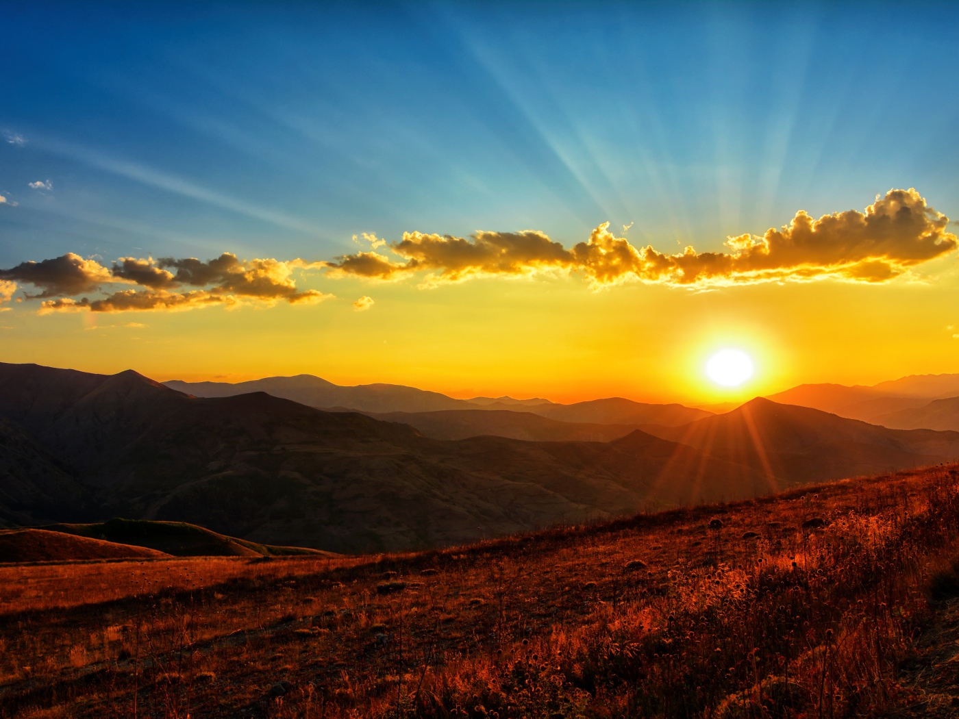 Красивый рассвет в небе над зелеными холмами