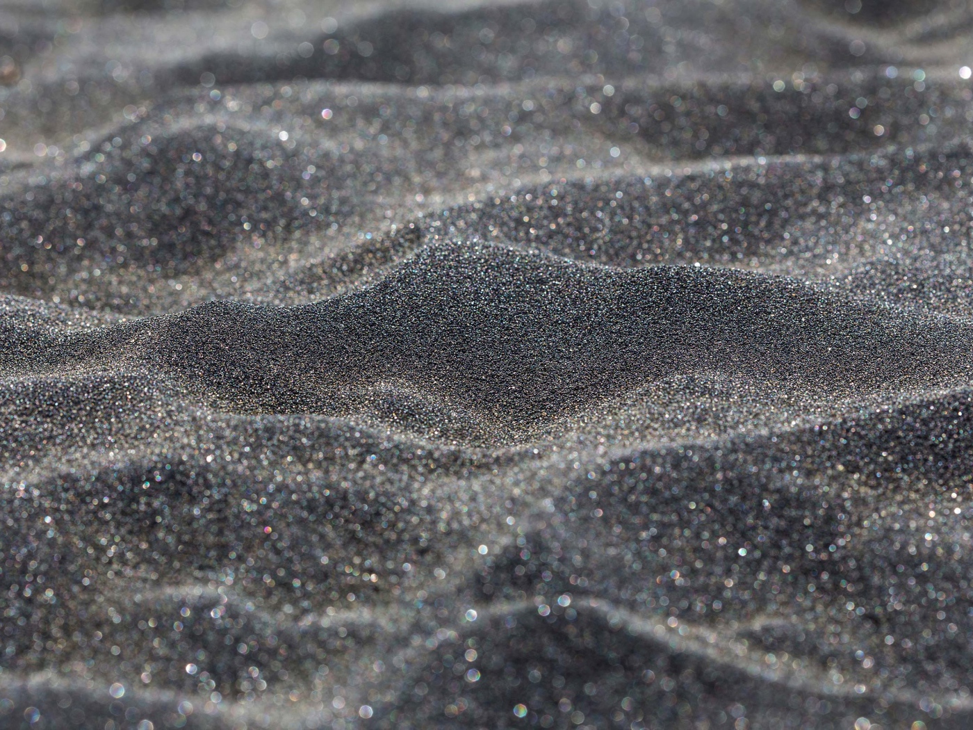 Блестящий черный песок крупным планом