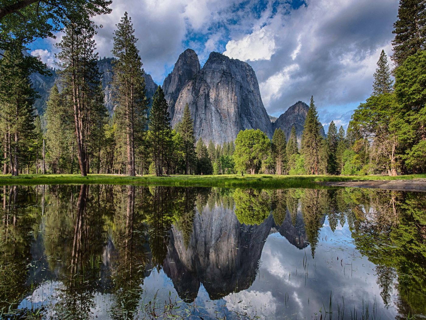 Каменные скалы и лес отражаются в воде 
