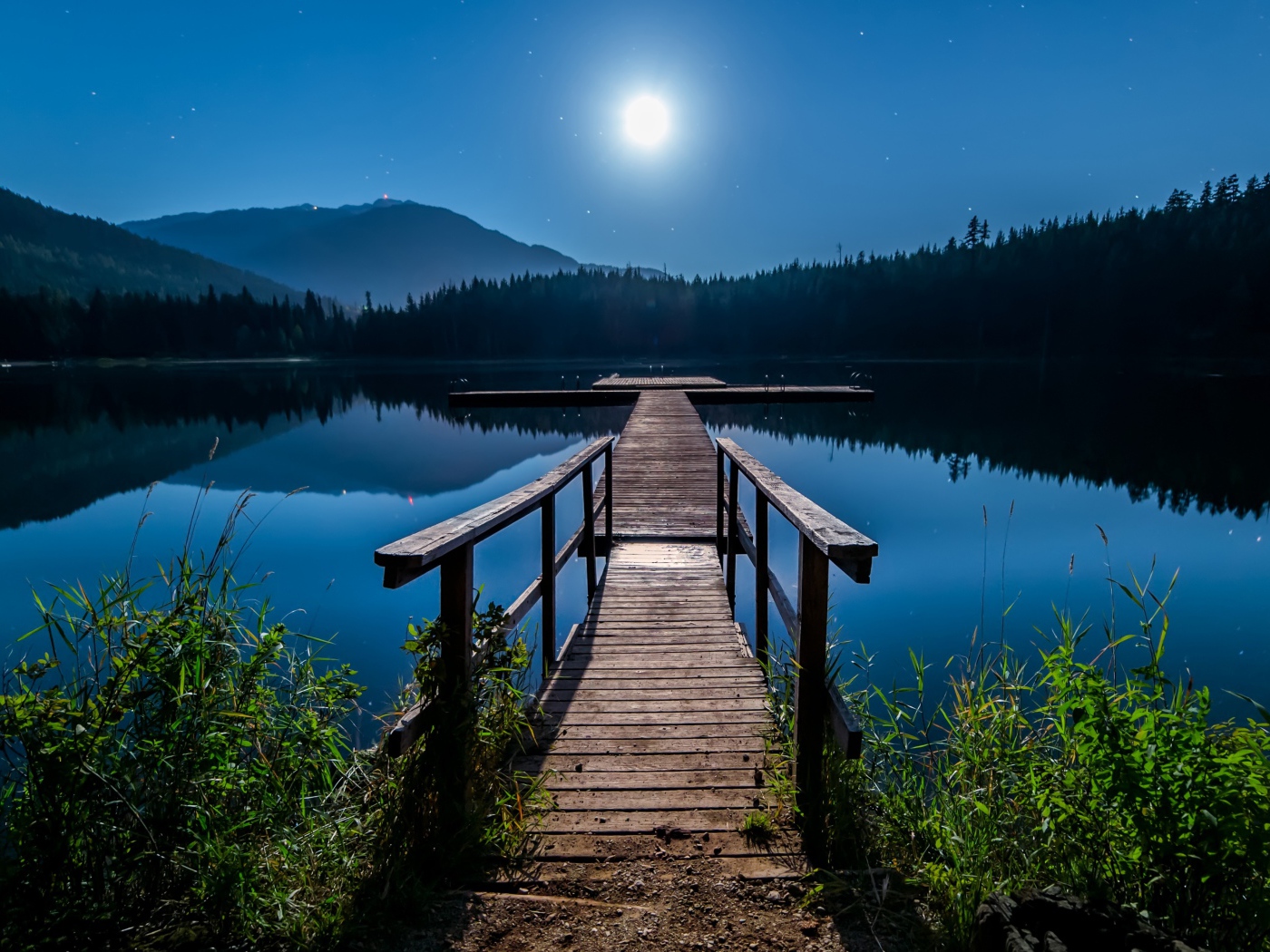 Деревянный мост на озере в полнолуние