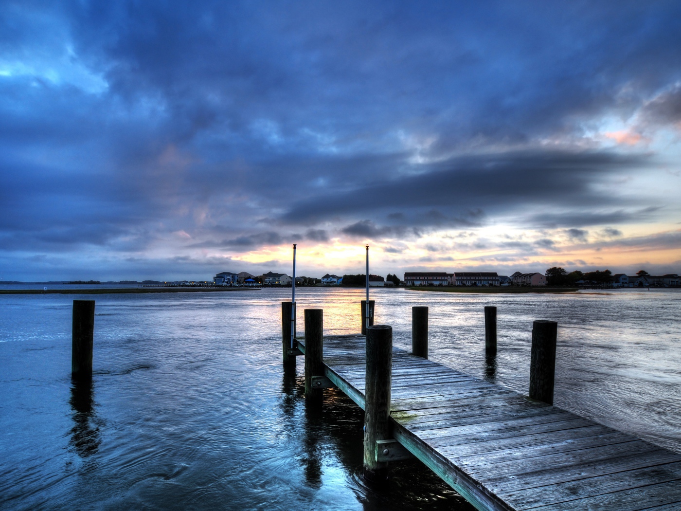 Деревянный мост на реке на фоне неба в сумерках