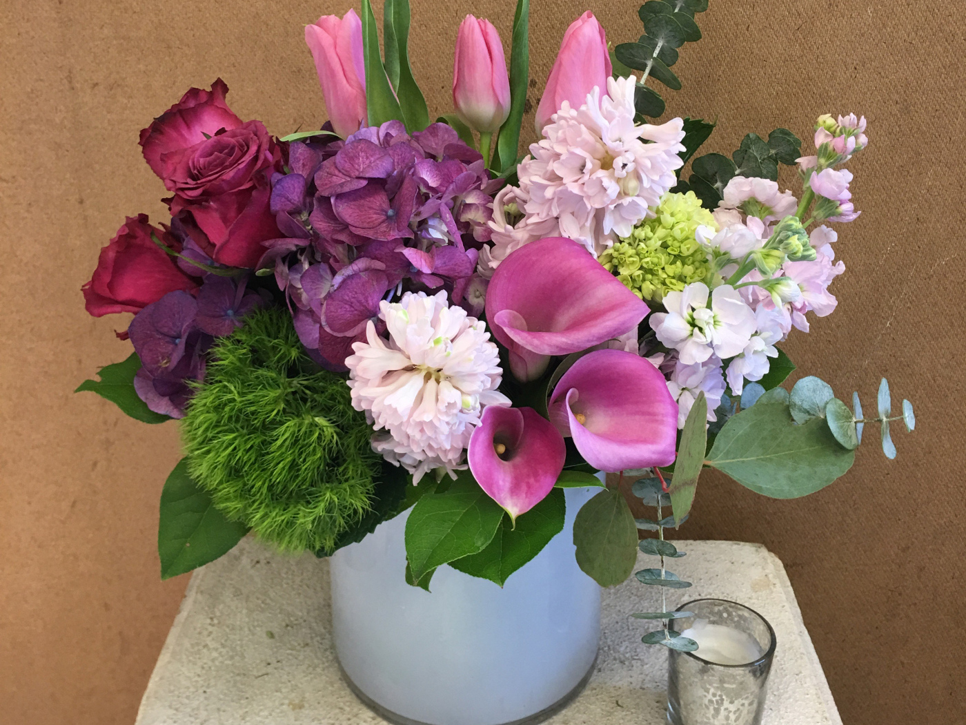 Красивый букет цветов в вазе у стены