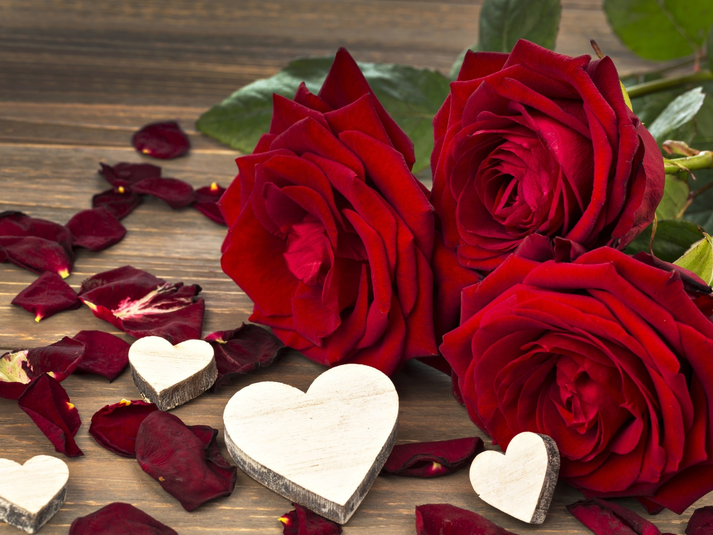 Три крупные красные розы с деревянными сердечками