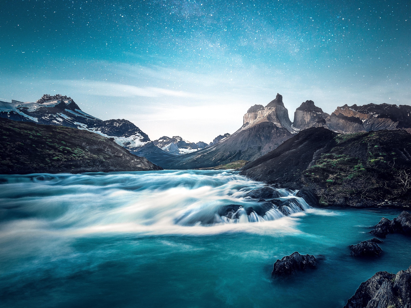 Быстрая вода к реке у гор на фоне голубого неба 