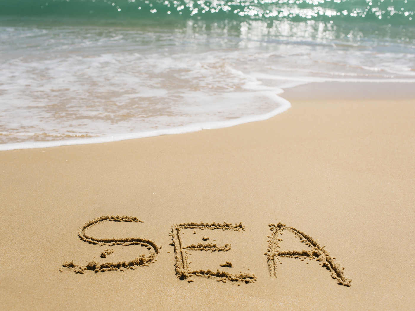 Надпись на песке у моря летом