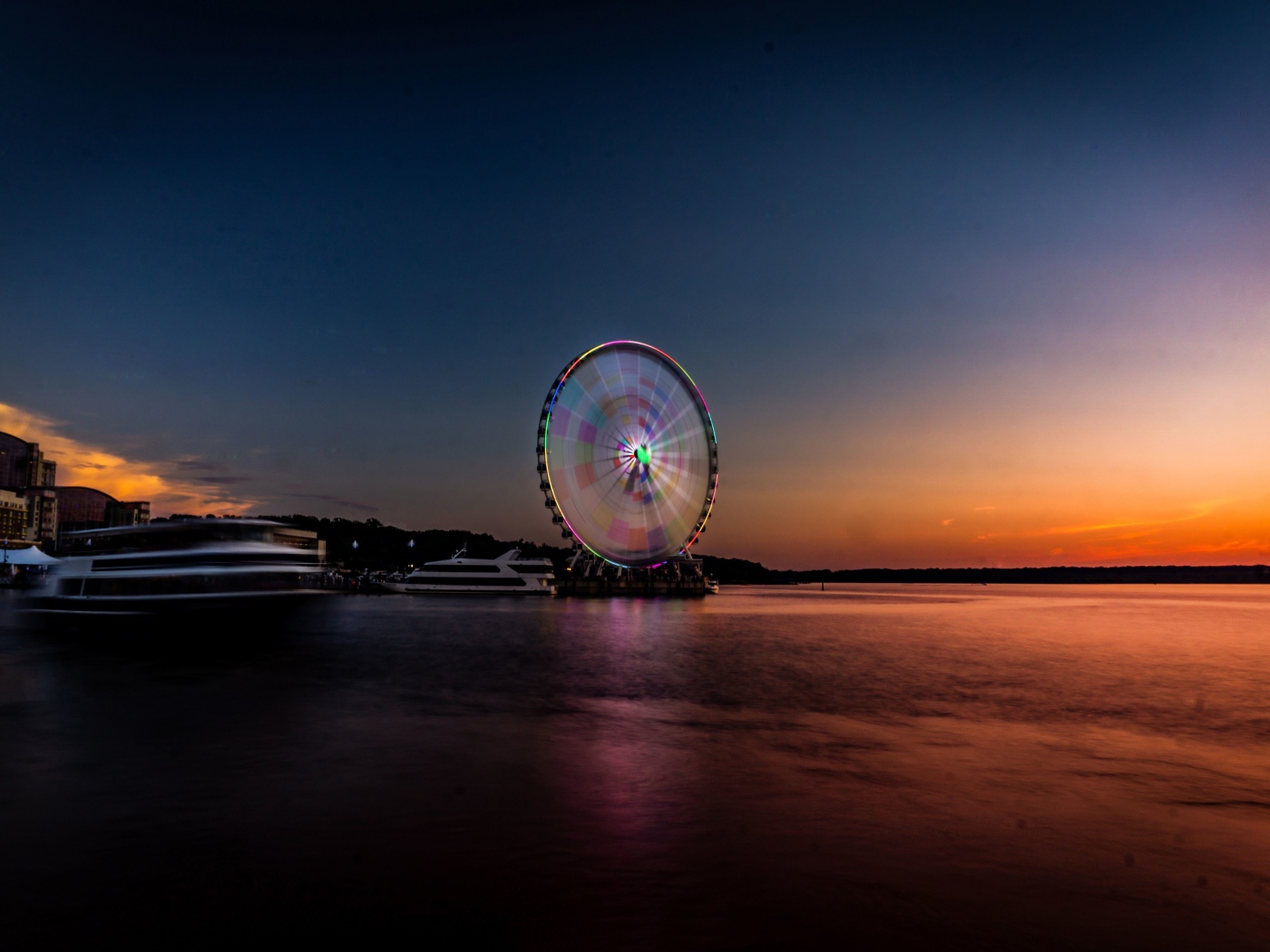 Колесо обозрения у воды на закате