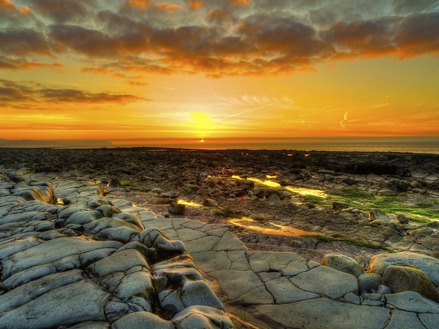 Каменный берег на фоне красивого неба на закате солнца