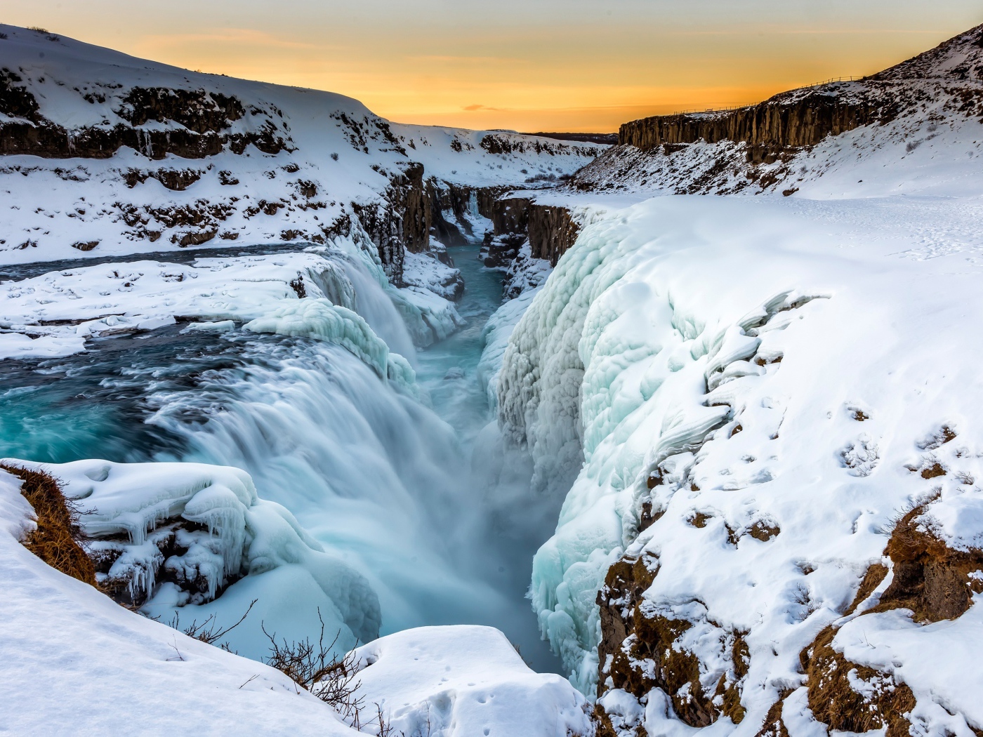 Заледеневший водопад у покрытых снегом берегов, Исландия