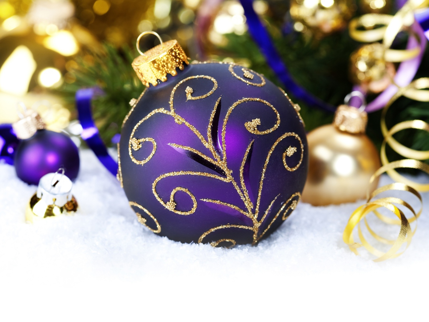 Красивая фиолетовая елочная игрушка лежит на снегу