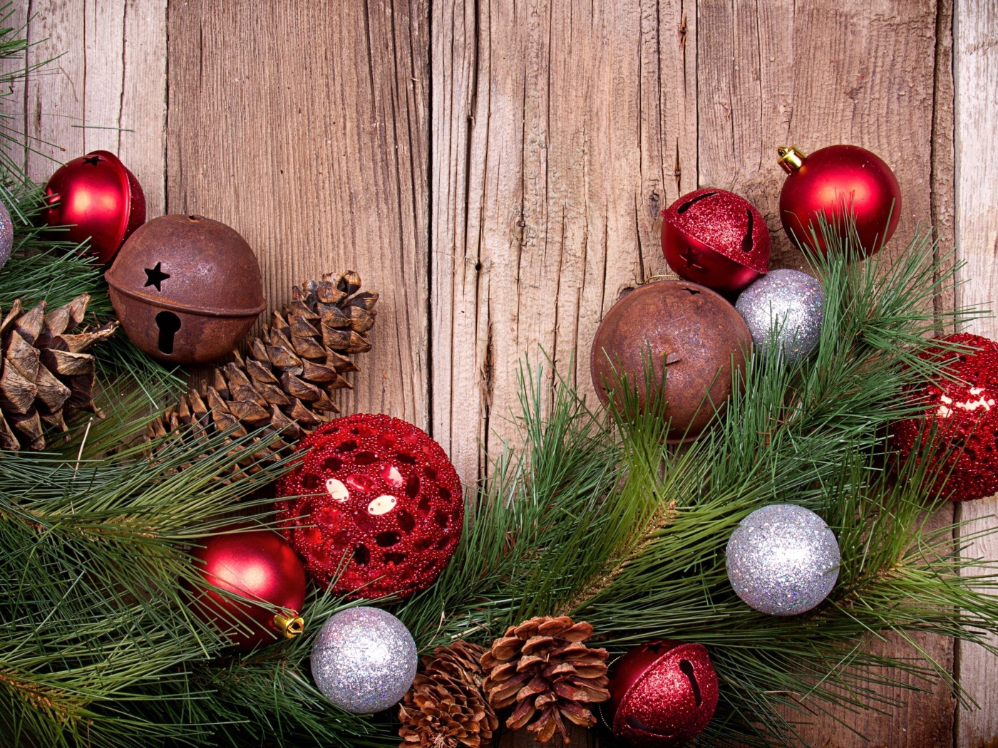 Зеленая еловая ветка с шишками и игрушками на деревянном фоне