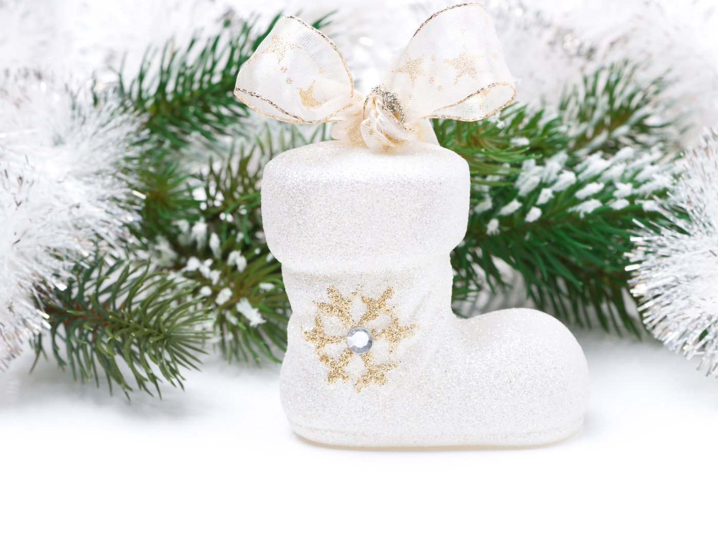 Ботинок с бантом и зеленая еловая ветка на белом фоне на Новый год 