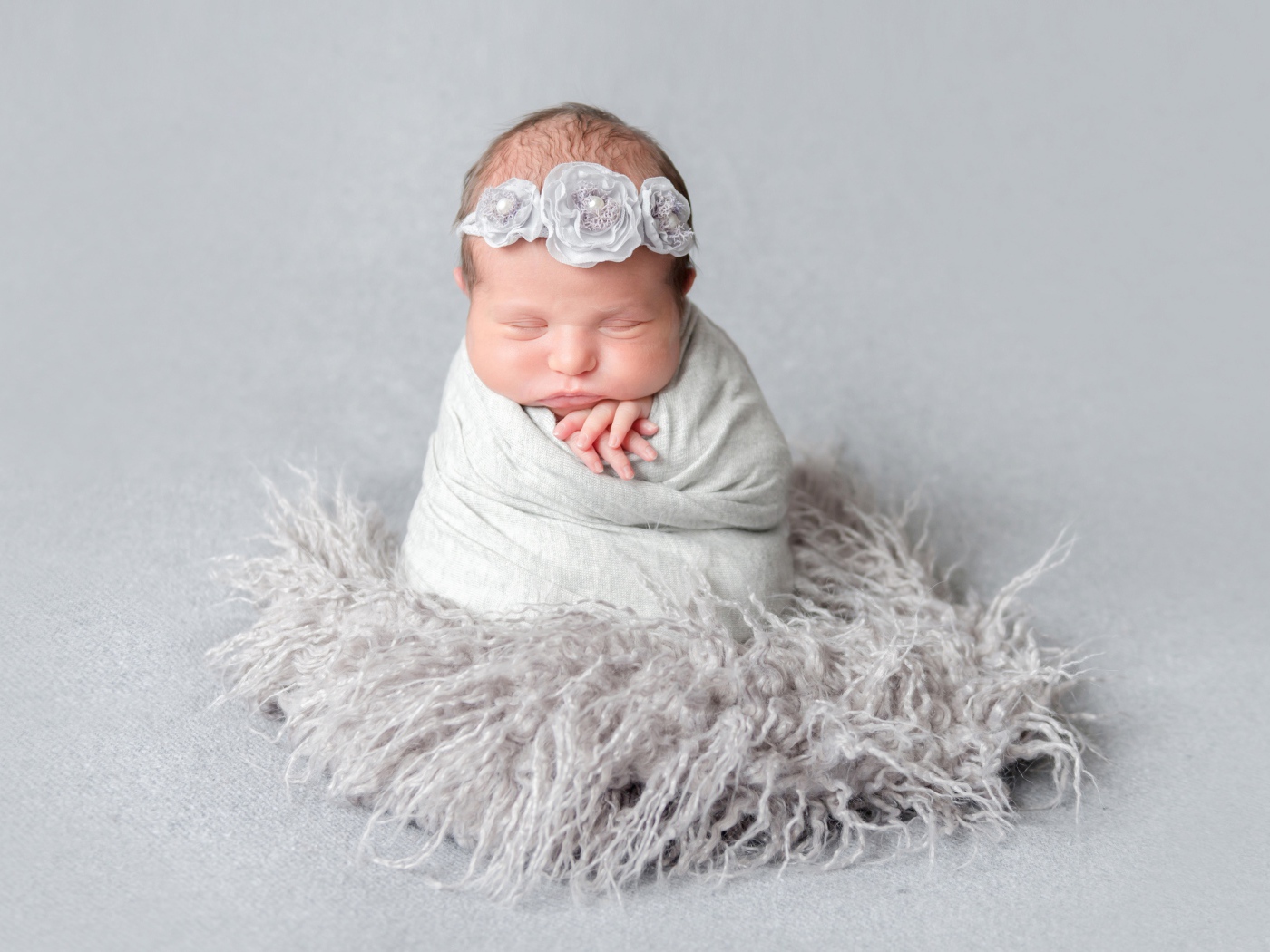 Маленький спящий младенец на сером фоне