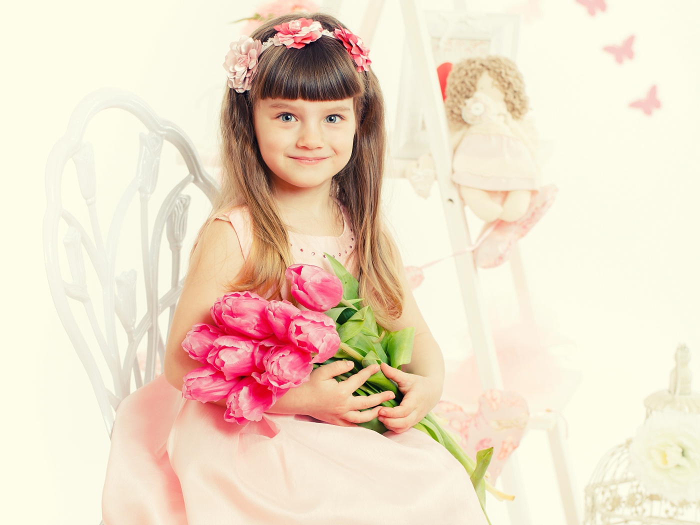 Красивая милая голубоглазая девочка с букетом розовых тюльпанов