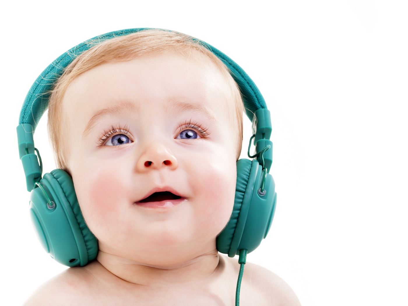 Милый младенец в больших наушниках на белом фоне