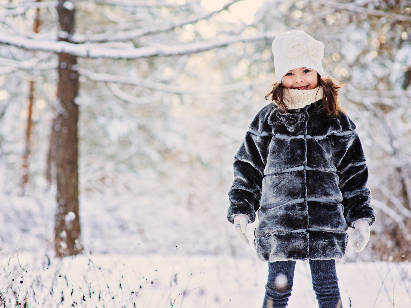 Милая маленькая девочка в шубе зимой