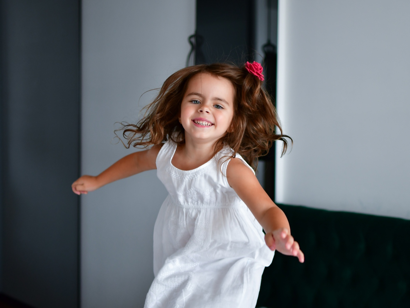 Маленькая веселая девочка в белом платье