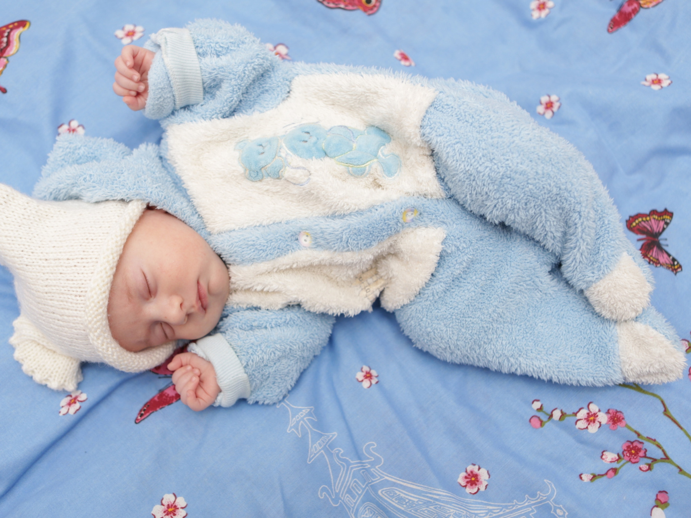 Грудной спящий ребенок в голубом костюме