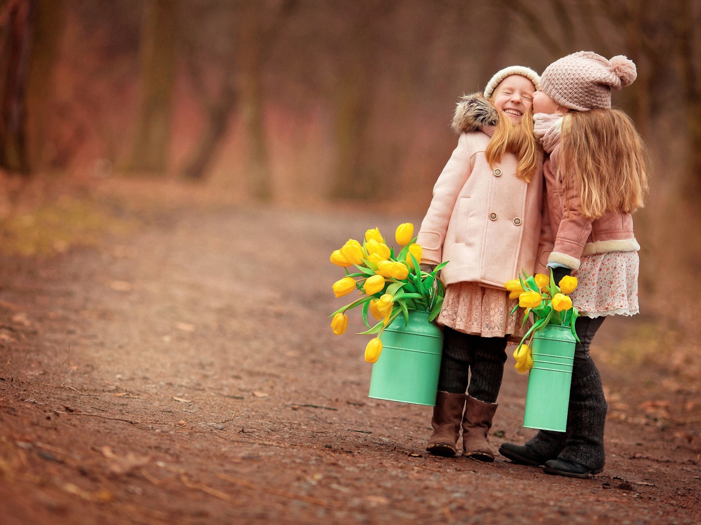 Две маленькие девочки с желтыми тюльпанами весной