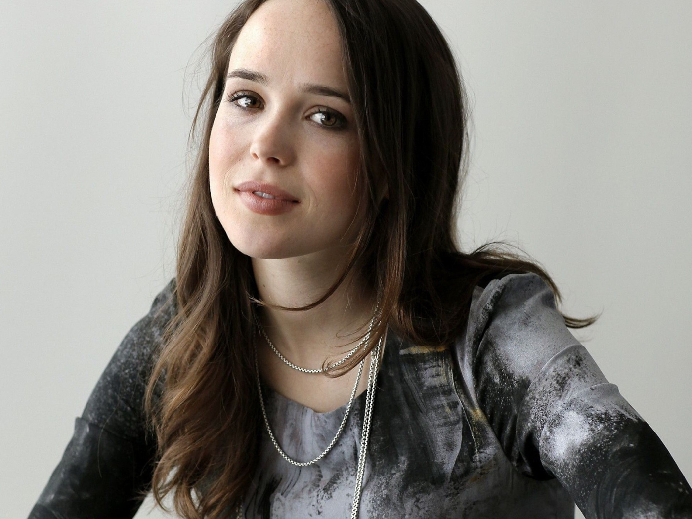 Красивая шатенка, актриса Эллен Пейдж фото на сером фоне